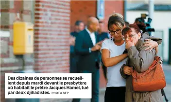  ??  ?? Des dizaines de personnes se recueillen­t depuis mardi devant le presbytère où habitait le prêtre Jacques Hamel, tué par deux djihadiste­s.