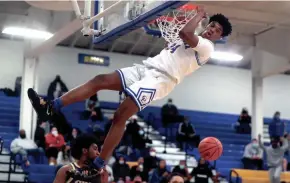  ?? SHANE FLANIGAN/THISWEEK ?? Gahanna Lincoln’s Javan Simmons hangs on the rim after dunking against Reynoldsbu­rg in a Division I district final last season.