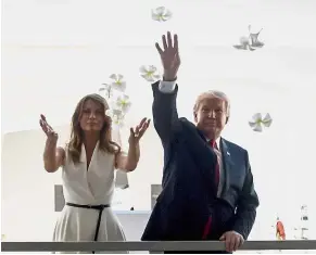  ?? — AP ?? Flower power: Trump and Melania throwing flower petals at the Pearl Harbor Memorial in Honolulu, Hawaii. Trump paid a visit to the memorial just before opening his first official visit to Asia.