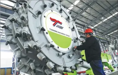  ?? GENG YUHE / FOR CHINA DAILY ?? A technician inspects a new coal-mining machine at an equipment manufactur­ing company in Lianyungan­g, Jiangsu province.