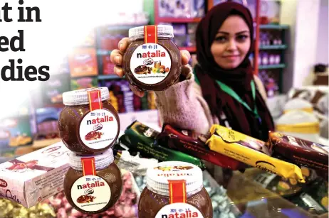  ??  ?? A shop employee holds up jars of a Gazan version of a world famous spread, dubbed ‘Natalia’, in Gaza city.