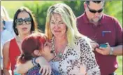  ??  ?? A woman and her daughter react following shooting at Marjory Stoneman Douglas school in Parkland, Florida, on Wednesday.