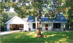  ?? PHOTOS BY LINDA GARNER-BUNCH/Arkansas Democrat-Gazette ?? A welcoming porch adds to the classic character of this two-story home. Inside are formal and casual living spaces, two master suites, an of  ce and more.