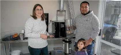  ?? WARWICK SMITH/ STUFF ?? Nicole and Aron Sinarahua and their daughter Gaia, 2, prepare to roast a batch of Peruvian coffee beans in their roasting room, attached to their garage in Woodville.