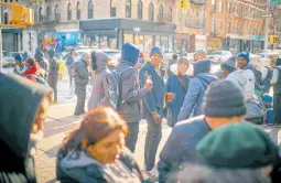  ?? ?? Migrants having warm drinks as mutual aid groups distribute food and clothes under cold weather near the Migrant Assistance Center at St Brigid Elementary School in New York.