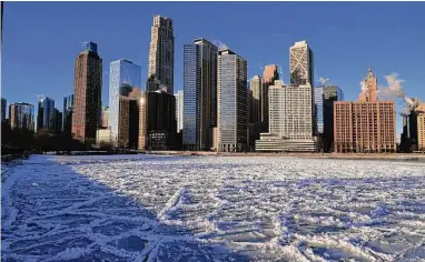  ?? Kiichiro Sato/Associated Press ?? Ice covers Lake Michigan on Friday in Chicago. An Arctic front is expected in New England over the weekend, and about 30 percent of Austin customers have been without power since Monday.
