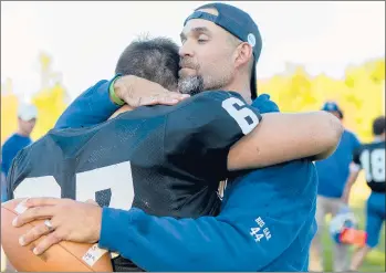  ?? JOHNATHON HENNINGER/THE HARTFORD COURANT ?? Brian Mazzone, the coach of the Stafford/Somers/East Windsor co-op football team, hugs Ryan Hoefle, one of his players, after the team beat Valley Regional/Old Lyme on Saturday. Mazzone’s father, Gary, was among those killed Wednesday in the B-17 bomber crash at Bradley Internatio­nal Airport, and this was his first game since the accident.