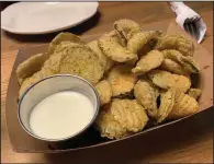  ?? (Arkansas Democrat-Gazette/Eric E. Harrison) ?? A paper basket contains a plenitude of fried pickles with a mild ranch dressing for dipping at The Library Kitchen + Lounge.