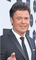  ?? GETTY IMAGES ?? Donny Osmond gets down in a theme song and gonzo video.