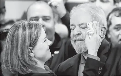  ??  ?? La presidenta del Partido del Trabajo, senadora Gleisi Hoffmann, limpia el sudor de la cara del ex presidente Luiz Inacio Lula da Silva ■ Foto Ap