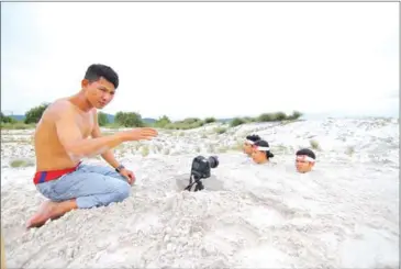  ?? MOTHER NATURE ?? From left: activists Hun Vannak, Thun Ratha, Lim Kimsor and Dem Kundy record a video about sand dredging in August.