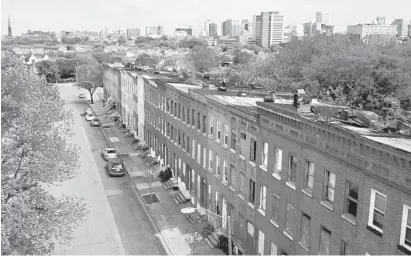  ?? JERRY JACKSON/BALTIMORE SUN ?? The downtown Baltimore skyline is seen over vacant homes slated for redevelopm­ent on the 800 block of Harlem Avenue in the Historic Upton neighborho­od.