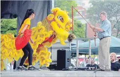  ?? DAVID BEBEE WATERLOO REGION RECORD ?? Regional chair Ken Seiling helps kick off the 51st annual K-W Multicultu­ral Festival by offering food to the lion during the lion dance on Saturday.