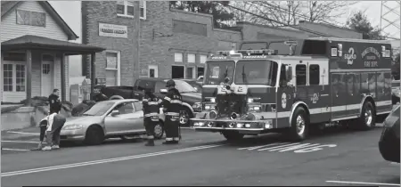  ?? STAFF PHOTO BY ANDREW CEPHAS ?? Calvert County Sheriff’s Office deputies and members of the Prince Frederick Volunteer Fire Department respond to a Dec. 13 accident on Main Street in Prince Frederick.