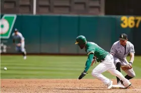  ?? Jeff Chiu / Associated Press ?? The A’s Starling Marte prepares to head toward third after a pickoff throw eluded Chicago second baseman Cesar Hernandez in the third inning.