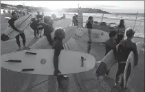  ?? RICK RYCROFT / ASSOCIATED PRESS ?? Surfers wait for officials to open Bondi Beach in Sydney on Tuesday, as COVID-19 pandemic restrictio­ns are eased. The beach is open to swimmers and surfers to exercise only.