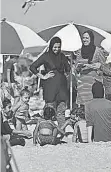  ?? DANIELLE PARHIZKARA­N, THE RECORD ?? Amanny Khattab, center, a school principal in Passaic, wears a burkini with her family at Point Pleasant Beach, N. J., on Sunday.