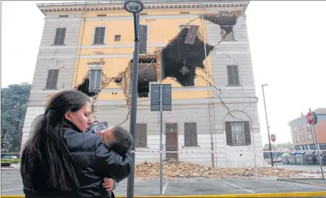  ?? Picture: Reuters ?? DEVASTATIO­N: A woman and her child stand in front of the badly damaged Town Hall at Sant’ Agostino, near Ferrara.