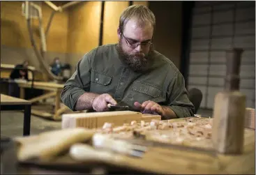  ?? NWA Democrat-Gazette/CHARLIE KAIJO ?? Philipp Richter of Bentonvill­e creates saw ponies for a bench he’s building Saturday during the first Northwest Arkansas Startup Weekend at Harris French and Associates Design Lab in Bentonvill­e.