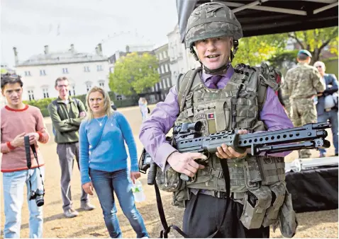  ?? ?? Alex Aiken, pictured during a Territoria­l Army recruitmen­t day, is quitting his government role. His wife Nickie, inset, will step down as a Tory MP at the next election