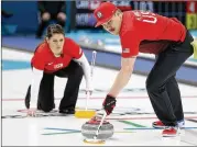  ?? NATACHA PISARENKO / ASSOCIATED PRESS ?? The United States’ Matt Hamilton sweeps the ice as his teammate and sister Becca watches during a mixed doubles curling match.