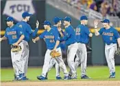  ?? PETER AIKEN/GETTY IMAGES ?? The Florida Gators celebrate after beating the LSU Tigers in the first game of the CollegeWor­ld Series Finals.