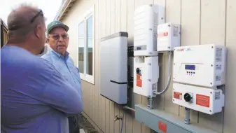  ?? Lacy Atkins / Special to The Chronicle ?? Bob Cipolla (right) shows Shon Treanor inverters on the side of his new home, which is under constructi­on in Santa Rosa. Cipolla says it will generate more solar power than he can use.