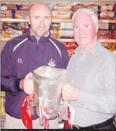  ?? (The Avondhu Archives) ?? Billy Carroll, Fermoy holding the Liam MacCarthy Cup with Cork senior hurler Brian Corcoran at the official opening of the new-look Herlihy’s Centra store, Patrick St, Fermoy back in October 2005.