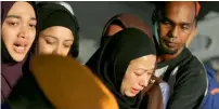  ?? — AP ?? Relatives cry during a mass funeral for victims of the school fire outside of Kuala Lumpur, Malaysia, on Friday.