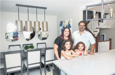  ?? COLE BURSTON TORONTO STAR ?? There’s lots of room for Paul and Christine Ceccomanci­ni and their daughters Olivia, left, and Ava at the new, long island in their kitchen that now opens to the dining area.