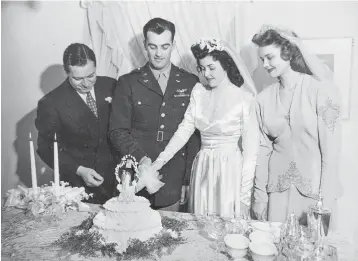  ?? Courtesy photo ?? left
Bettye DeYoung, right center, is shown cutting her wedding cake with her husband, Art DeYoung, in 1941 while wearing the same wedding dress that would later be worn by her daughter-in-law Ofelia DeYoung and her granddaugh­ter Jennifer Kramer at...