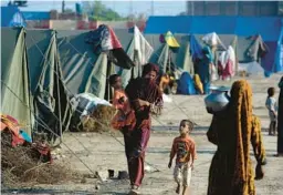  ?? FAREED KHAN/AP ?? Victims of heavy flooding from monsoon rains take refuge Saturday at a temporary tent camp set up by the U.N. refugee agency UNHCR in Sukkur, Pakistan.