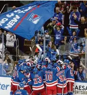  ?? John Munson/Associated Press ?? The New York Rangers and fans celebrate a victory over the Islanders on Saturday in New York.