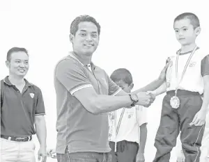  ??  ?? PENGERUSI Pemuda Barisan Nasional (BN) Khairy Jamaluddin (dua, kiri) yang merupakan calon BN Parlimen Rembau menyampaik­an hadiah kepada murid yang memenangi Hari Sukan Sekolah Rendah Jenis Kebangsaan (C) Chung Hua pada Ahad.