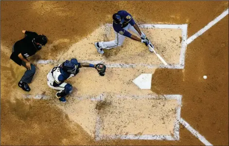  ?? (AP/Morry Gash) ?? Lorenzo Cain of the Milwaukee Brewers hits a single during an intrasquad game in Milwaukee last week. As baseball attempts to play a shortened regular season amid a coronaviru­s pandemic, there is concern that home plate could become a hot spot for transmissi­on.