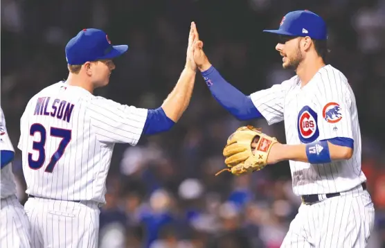  ?? | PAUL BEATY/ AP ?? Cubs manager Joe Maddon says reliever Justin Wilson ( left, with Kris Bryant) could make a big difference down the stretch and possibly in the postseason.