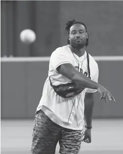  ?? Karen Warren / Houston Chronicle ?? Akins harkens back to a former career while tossing out the first pitch before an Astros game on June 3.