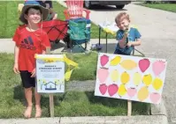  ?? PROVIDED BY THE RANEY FAMILY ?? George Raney, 7, left, runs a lemonade stand at his Far West Side home in August with the help of his brother, Theodore, 4. George came up with the idea, and used the money he raised to buy balloons to deliver to patients at Ohiohealth Doctors Hospital, where his father Aaron is a resident surgeon.