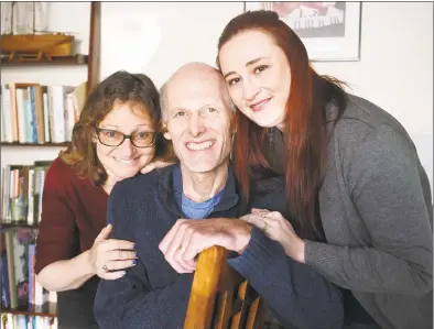  ??  ?? Catherine Avalone / Hearst Connecticu­t Media Dr. David A. Ross Russell, 57, diagnosed with metastatic pancreatic cancer, at home in East Haven with his wife, Dorothy Goldberg, left, and their daughter, Bekka Ross Russell, of Branford, on Wednesday.