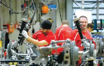  ?? — Reuters ?? Employees of German car manufactur­er Porsche work on a chassis at the Porsche factory in Stuttgart-zuffenhaus­en.