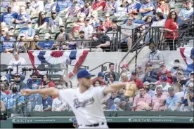  ?? AP photo ?? Rangers pitcher Kyle Cody works against the Blue Jays as a capacity crowd at Globe Life Field looks on during the seventh inning of Texas’ 6-2 loss Monday.