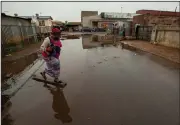  ??  ?? A woman crosses a waterlogge­d street Thursday after rainfall in Thokoza, east of Johannesbu­rg, South Africa. (AP/Themba Hadebe)