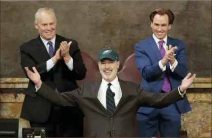  ?? ASSOCIATED PRESS ?? Democratic Gov. Tom Wolf puts on a Philadelph­ia Eagles hat to celebrate their Super Bowl win before he gives his budget address at the state Capitol in Harrisburg on Tuesday.