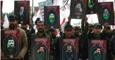  ?? AFP ?? Members of Iraq’s Popular Mobilisati­on Forces hold portraits of militia members killed in Friday’s US strikes