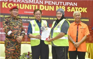  ??  ?? Abang Johari (second left) presents a certificat­e to a Bomba Komuniti member, who is among 20 registerin­g for FoFF. At right is Kuching North Datuk Bandar Datuk Abang Abdul Wahap Abang Julai, while at left is Khirudin.