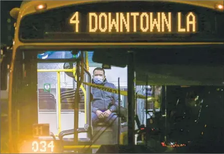  ?? Photog r aphs by Robert Gauthier Los Angeles Times ?? A COMMUTER RIDES a Metro bus in downtown L. A. on Friday, as coronaviru­s infections surged and new restrictio­ns were enacted. California averaged more than 11,500 new cases each day in the week that ended Saturday, more than three times the number Oct. 21.