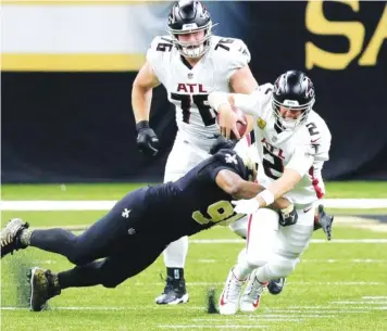  ?? AP PHOTO/ BUTCH DILL ?? Atlanta Falcons quarterbac­k Matt Ryan is sacked by New Orleans Saints outside linebacker Demario Davis in the second half of Sunday’s game in New Orleans. The Saints sacked Ryan eight times as the Falcons lost 24-9.