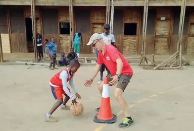  ??  ?? Mario Ferradini a Nairobi mentre insegna a uno dei bambini del progetto Slums Dunk