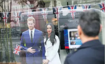  ?? DANIEL LEAL-OLIVAS/AFP/ GETTY IMAGES ?? A pedestrian takes a photograph Wednesday of memorabili­a in a central London shop window celebratin­g the forthcomin­g wedding of Prince Harry and Meghan Markle.