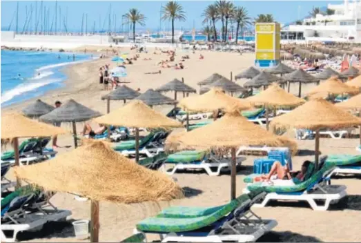  ?? MARÍA JESUS SERRANO ?? Un grupo de personas toman el sol en la playa de la Venus de Marbella.